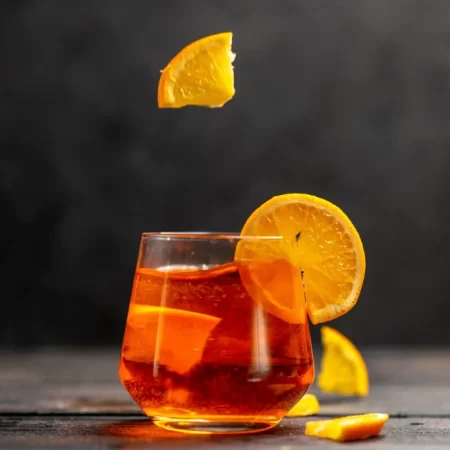 horizontal-view-fresh-delicious-juice-glass-with-orange-limes-dark-background_140725-140818